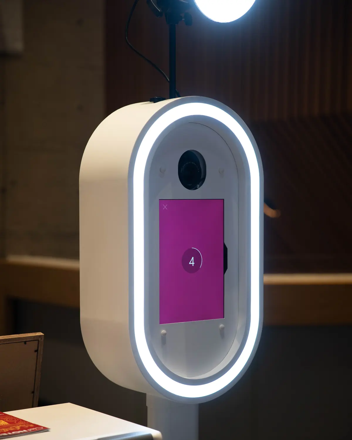 Close up of the attended Aura booth with its ring light on and the printer below it