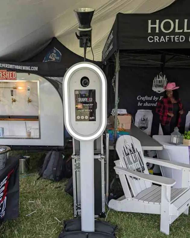 The Aura booth at a festival with a client's branded start screen showing on the booth screen
