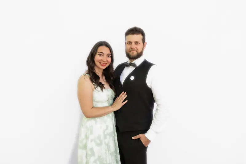 A couple in formal wear posing in the Aura photo booth