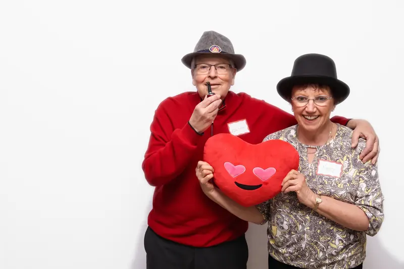 Two guests wearing event name tags in the Aura photo booth