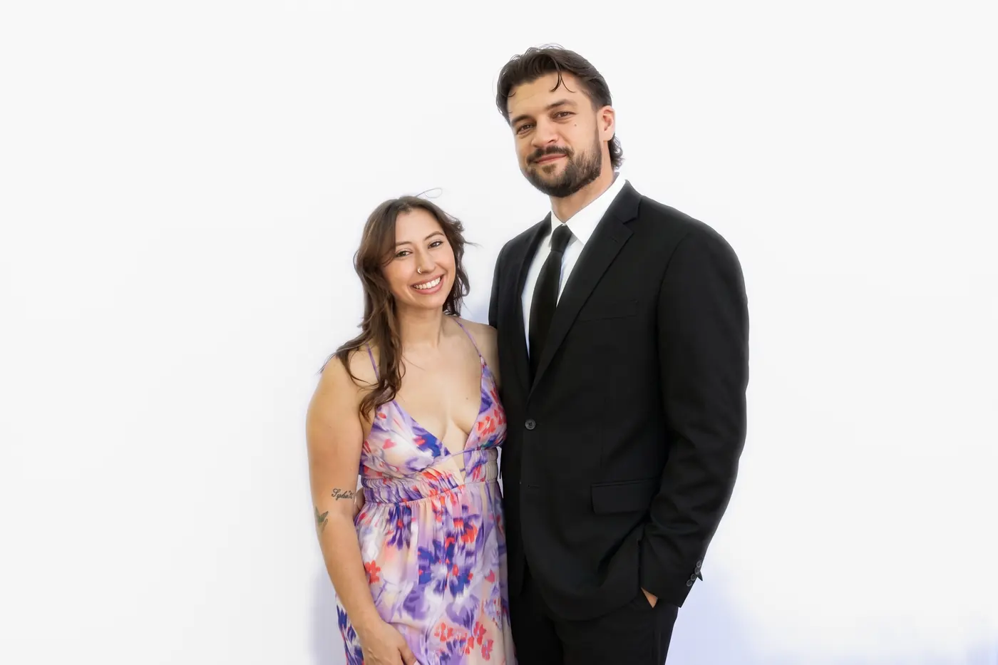 Two guests photographed against the clean white studio backdrop